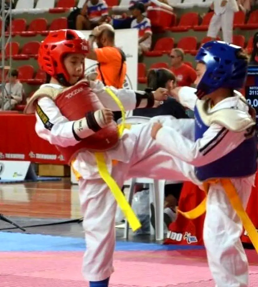 Duas jovens atletas em uma competição de taekwondo
